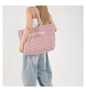 Macro shot of red and white striped canvas tote bag with white summer text embroidery