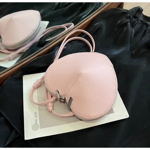 Dettaglio della borsa in pelle rosa a forma di cuore con doppia cerniera e cuciture