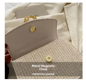 Detail of magnetic snap closure and woven texture on a beige crossbody bag with gold chain
