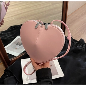 Dettaglio della borsa a tracolla rosa a forma di cuore con pelle opaca e zip argento