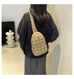 Rear view of khaki quilted nylon crossbody bag with wide adjustable strap on model