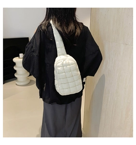 Detailed back view of a white quilted crossbody bag worn over a beige sweater