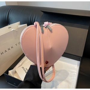 Dettaglio della borsa a tracolla rosa chiaro a forma di cuore con pelle PU e doppia cerniera