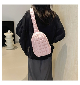 Detailed view of pink quilted nylon crossbody bag with bubble texture and metallic zipper