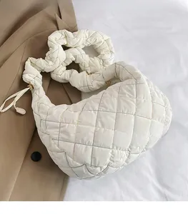 Detail of white quilted nylon crossbody bag with colorful stitching and ruched strap