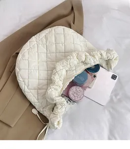 Detail of quilted nylon crossbody bag showing large capacity with tablet and cosmetics