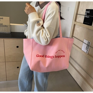 Pink canvas tote bag with Good Things Happen print and blue striped lining detail