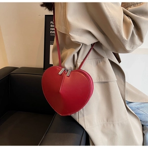 Dettaglio di una borsa a tracolla rosso acceso a forma di cuore con finitura lucida