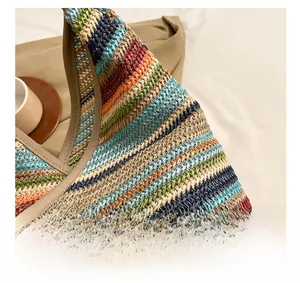 Detail showing the colorful woven texture and premium leather handles of the straw bag