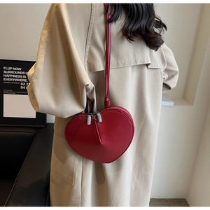 Dettaglio della borsa a tracolla rossa a forma di cuore in pelle opaca con doppia cerniera