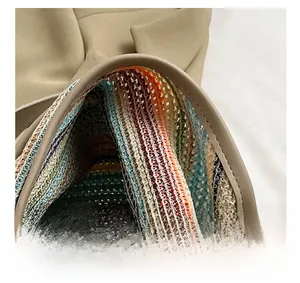 Close-up of khaki shoulder bag with colorful knitted stripe lining and open top design