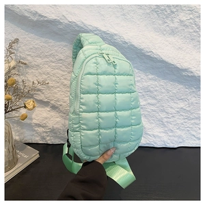 Mint green quilted nylon crossbody bag with dual zippers and sporty nylon strap