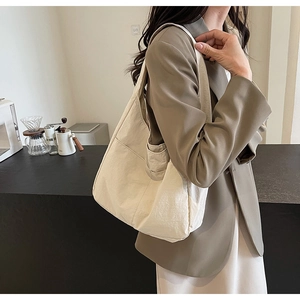 Bolso tote de lona beige minimalista con práctico bolsillo lateral y correa ancha