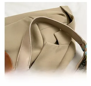 Detail of knitted shoulder strap with colorful wave pattern and beige leather stitching