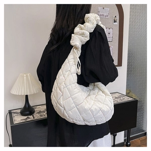 Close-up of white quilted nylon crossbody bag with colorful stitching and ruched strap