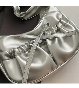 Detail of silver metallic PU shoulder bag with pleated texture and decorative bow