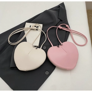 Dettaglio delle borse a tracolla in pelle PU a forma di cuore, beige e rosa
