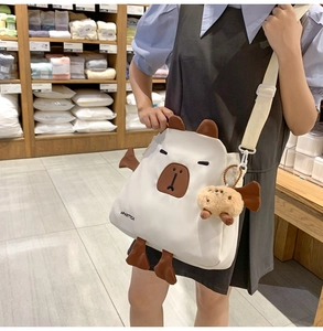 Détail du sac bandoulière blanc en nylon capybara avec oreilles 3D et pendentif peluche