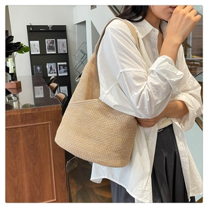 Detail of beige knitted tote bag with premium leather piping and minimalist shoulder strap