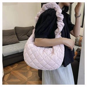 Detail of pink quilted nylon crossbody bag with ruffled strap and fluffy texture
