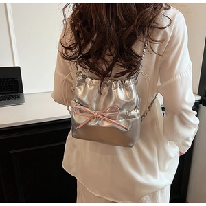 Sac argenté en PU avec nœud rose et bandoulière chaîne porté par un mannequin