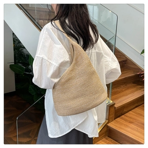 Chic straw woven shoulder bag in oatmeal hue styled with a white shirt for daily wear