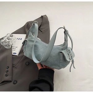 Light blue denim crescent shoulder bag with lace-up side pocket and adjustable strap
