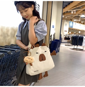 Détail du sac bandoulière en nylon beige avec design de capybara 3D et charm mignon