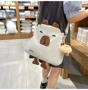 Détail du sac bandoulière en nylon capybara blanc avec oreilles 3D et breloque peluche