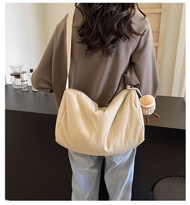 Beige canvas crossbody bag with a moon shape and cute plush coffee cup charm