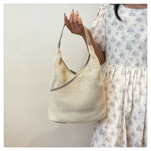 Detail of hand-woven cream shoulder bag showing refined texture and leather trim finish