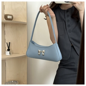 Détail du sac sous l'aisselle en cuir bleu clair avec fermoir nœud métallique
