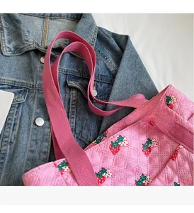 Pink quilted tote bag with strawberry print featuring reinforced fabric carry handles