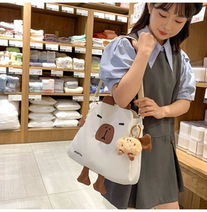 Sac bandoulière blanc motif animal avec peluche dans une ambiance de boutique