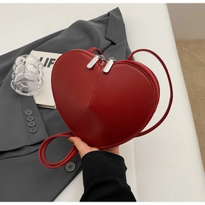 Dettaglio di una borsa a tracolla in pelle rossa a forma di cuore con doppia cerniera