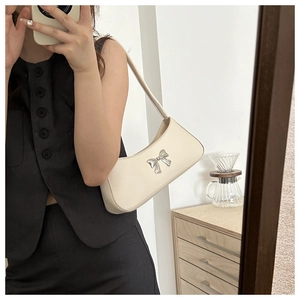 Détail du sac bandoulière demi-lune en similicuir blanc cassé avec boucle nœud argenté