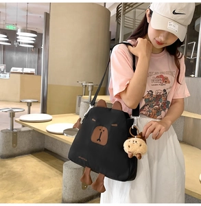 Détail du sac bandoulière noir en nylon avec oreilles 3D et breloque biscuit en peluche