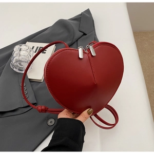 Dettaglio della borsa a tracolla rossa a forma di cuore con doppia cerniera argento
