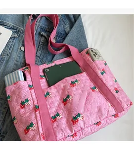 Pink quilted fabric tote bag detail showing large storage capacity for tablets and phones