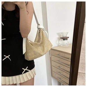 Detail of light beige woven straw crossbody bag with white leather strap and gold buckle