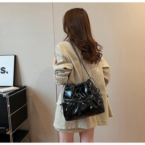 Sac bandoulière chic en cuir verni noir avec nœud coulissant et bandoulière chaîne