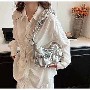 Detail view of silver metallic PU moon bag with drawstring bow and ruched shoulder strap