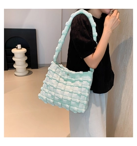 Detail view of mint green quilted cloud bag showing soft padded texture and shoulder strap