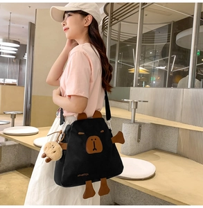 Détail du sac bandoulière en nylon noir avec oreilles d'ours 3D et pendentif mignon