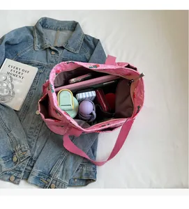 Detailed internal view of large capacity pink quilted strawberry tote bag with essentials
