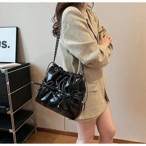 Détail du sac plissé noir brillant en cuir PU avec cordon de serrage et chaîne argent