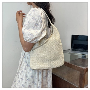 Detailed close-up showing the knitted texture of the ivory hobo bag with a soft strap