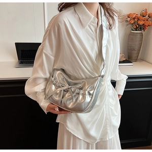 Detail of silver metallic PU shoulder bag with ruched bow and stylish crescent shape