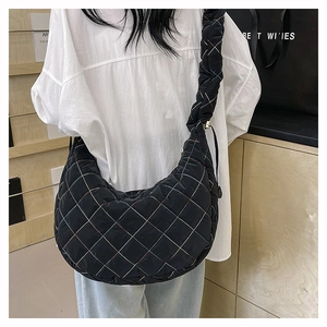 Detail of black quilted nylon hobo bag featuring colorful contrast stitching and a wide strap