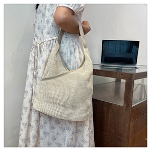 Detail showing the soft beige knitted texture and synthetic leather strap of this tote bag